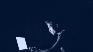 alt"パソコンから放たれているブルーライトを浴びている男性の画像"